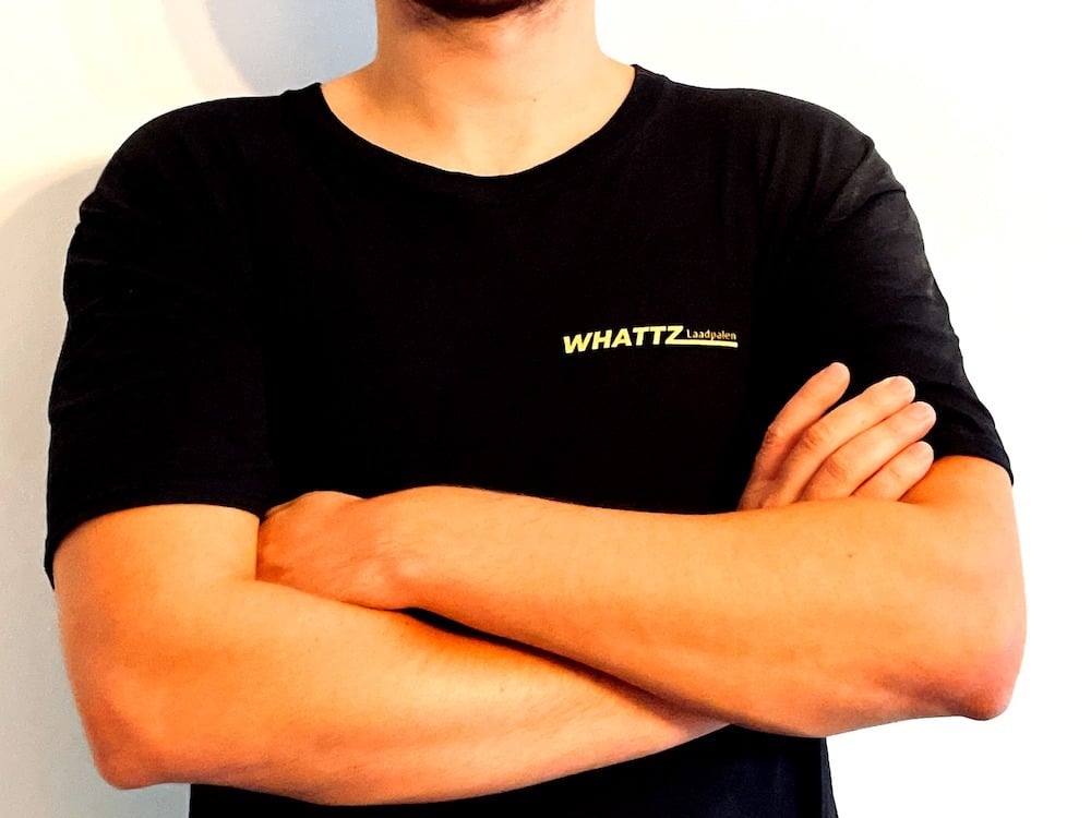 Foto van bovenlichaam zonder hoofd met zwarte T-shirt van WHATTZ laadpalen